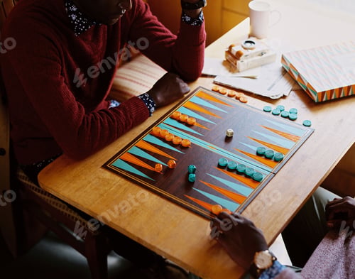 Preview: Closeup shot of two African men playing backgammon on a train