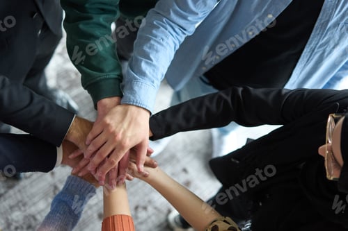 Preview: A top view of business people joining hands in a circle, symbolizing unity, collaboration, and