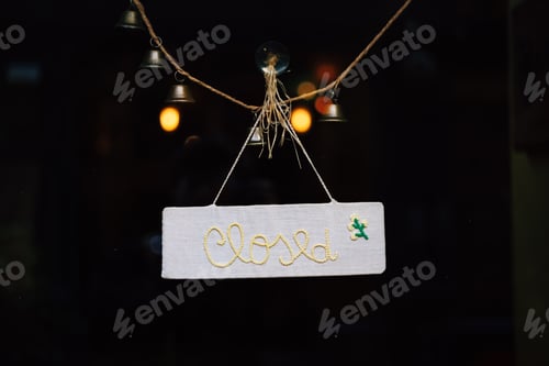 Preview: Closed sign hanging on glass door with bells and string, showing business temporarily unavailable