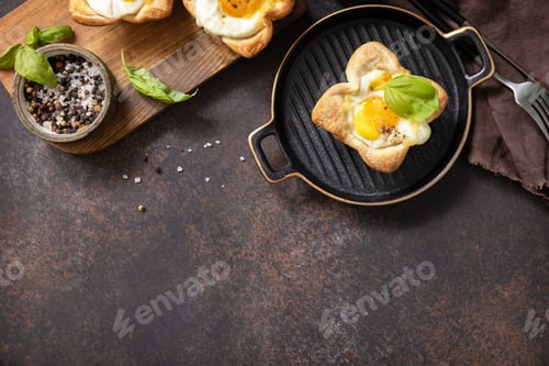 Preview: Scrambled eggs in puff pastry with cheese and bacon on a stone plate.