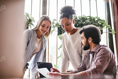Preview: Happy multiracial millennial colleagues discussing company financial statistics at briefing in