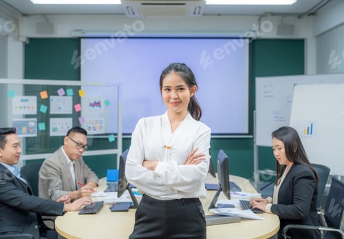 Preview: Portrait smiling modern business woman standing in an office at team meeting. Confident young Asian