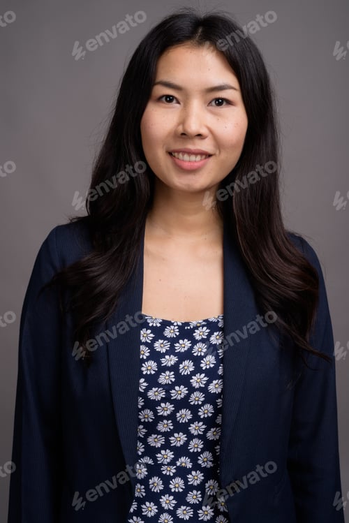 Preview: Asian woman wearing blue dress and cardigan sweater against gray