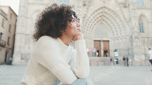 Preview: Young smiling woman explores the streets, looks up