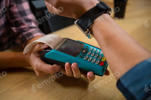 Preview: Cropped hand of customer making payment at bar