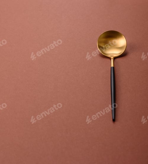 Preview: Empty metal spoon on a monochrome brown background
