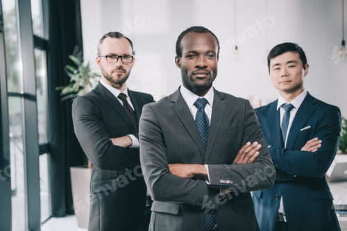 Preview: group of multiethic businessmen with folded arms looking at camera