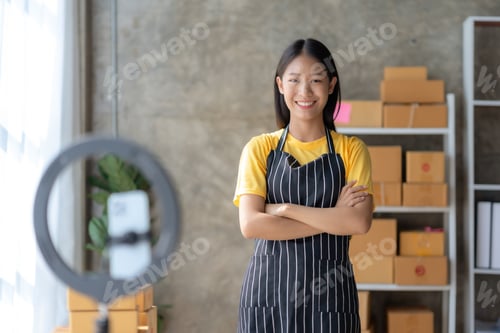 Preview: Young Asian online seller doing product review via video streaming live to social media at home.