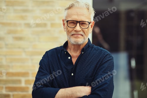 Preview: Senior man smiling while standing outside in his yard