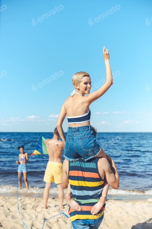 Preview: selective focus of interracial group of friends spending time on sandy beach