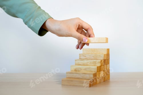 Preview: A business woman plays the game of wooden blocks placed at the top with a strategic strategy And pro