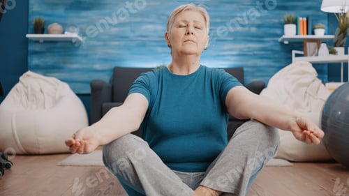 Preview: Aged woman doing meditation sitting in lotus position