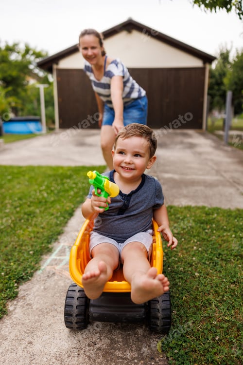 Preview: Mother having fun pushing child in toy truck