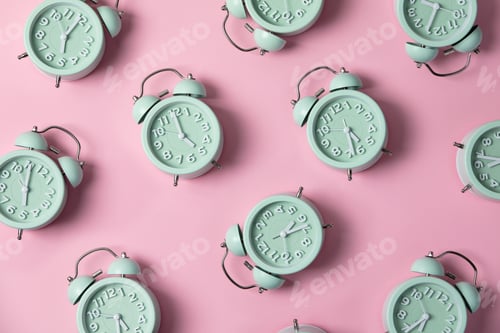 Preview: Creative layout of green alarm clock's on pastel pink background. Minimal concept.
