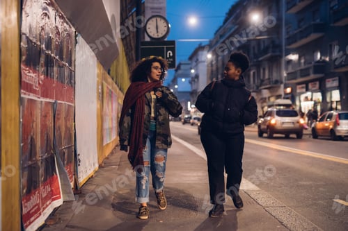 Preview: two brunette and curly girls walking in the street