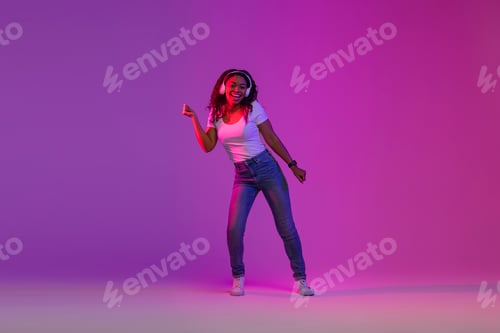 Preview: Feel The Beat. Black Woman In Wireless Headphones Dancing In Neon Light