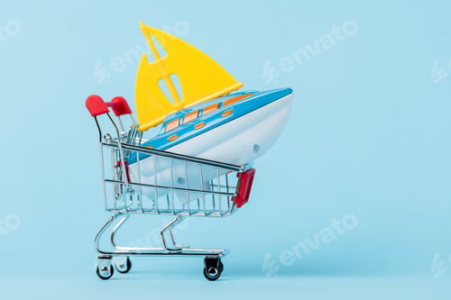 Preview: small shopping trolley with toy boat on blue, leasing concept