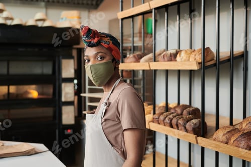 Preview: Saleswoman in mask in bakery shop