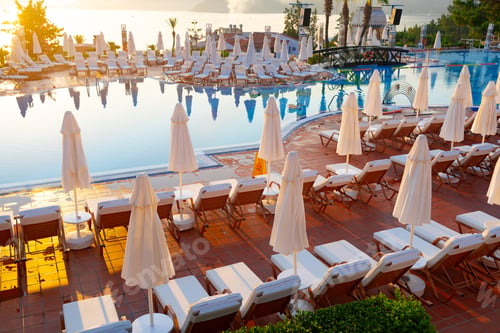 Preview: Pool with lounge chairs in resort hotel with mountain view