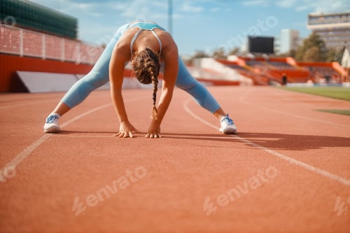 Preview: A sportswoman is stretching on stadium and preparing for exercise.
