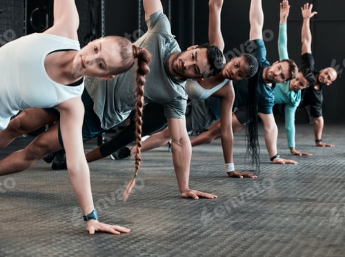 Preview: Breathe through the pain. Shot of a group of gym friends side planking together.