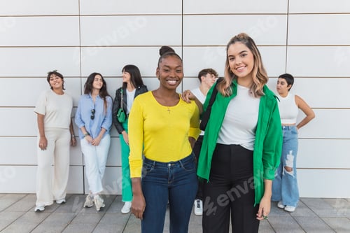 Preview: Happy diverse friends standing near wall