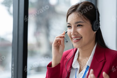Preview: Asian businesswoman employee or executive using laptop computer and wearing headset video call expla