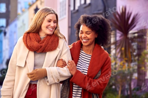 Preview: Woman Meeting Female Friend Walking Along Residential City Street In Fall Or Winter