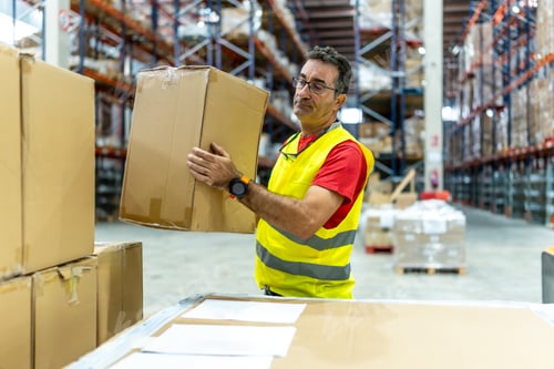 Preview: Man moving boxes in a warehouse to ship them