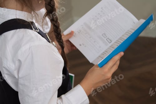 Preview: children are holding a notebook with homework assigned in the classroom