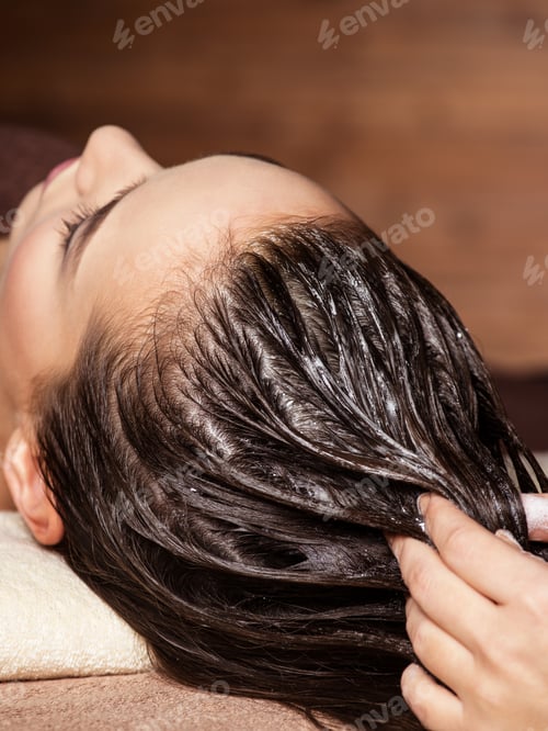 Preview: Cosmetologist massaging hair on the head of the woman. Spa treat