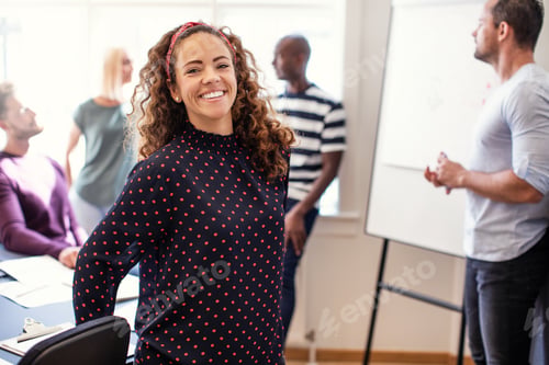 Preview: Young designer smiling after an office meeting with coworkers