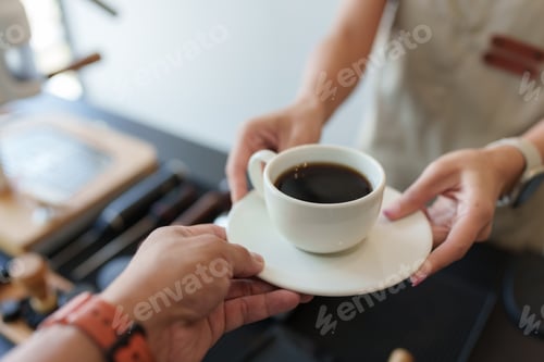 Preview: Barista serving a cup of freshly brewed coffee to customer