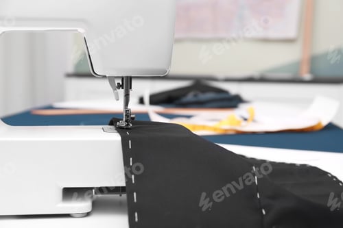 Preview: Sewing machine with fabric on table in tailor workshop, closeup