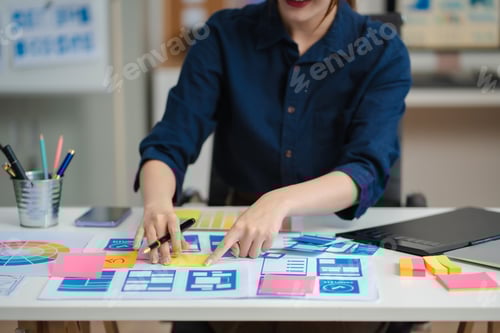 Preview: Female coder or developer working using a computer display and smartphone
