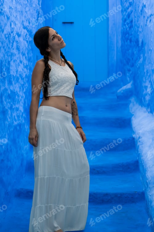 Preview: Young woman looking on blue wall