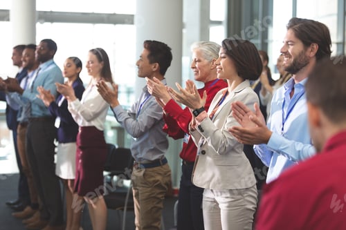Preview: Business people applauding standing in business seminar in office building
