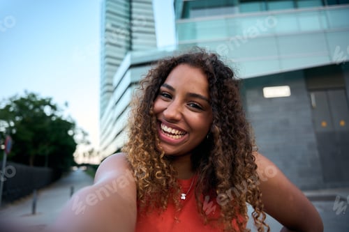 Preview: Trendy young woman smiling outdoors in city street, radiating youthful energy