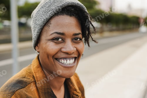 Preview: Young african woman smiling on camera in the city