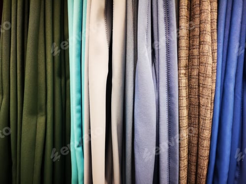 Preview: Closeup shot of clothing and multicolored trousers in graduation hanging on display