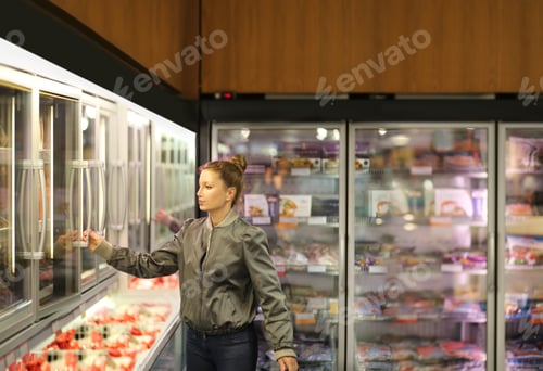 Preview: Woman Choosing Frozen Food From A Supermarket Freezer