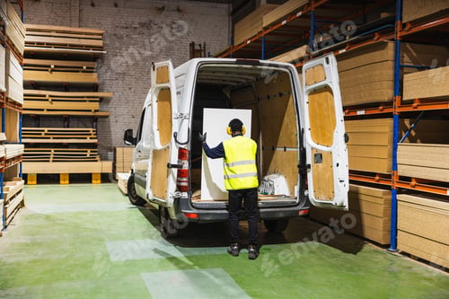 Preview: Worker loading plywood into delivery van in lumberyard
