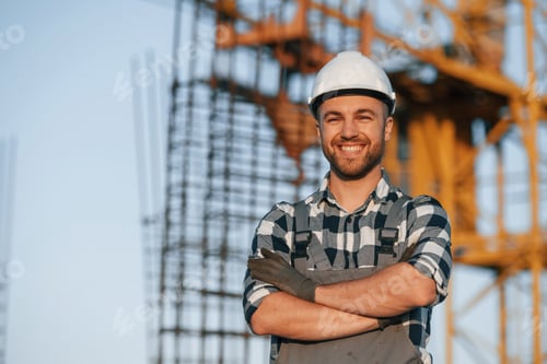 Preview: Happy worker is standing on the construction site at daytime