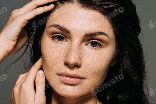 Preview: Portrait of attractive girl with freckles on face isolated on grey