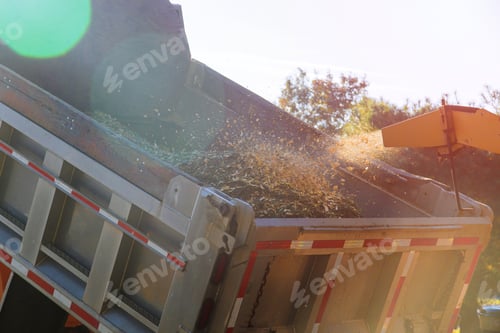 Preview: Wood chipper blowing tree branches cut a portable machine used for reducing wood into the back of a