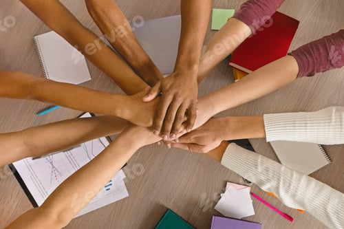 Preview: Multiracial teenagers joining hands together in cooperation