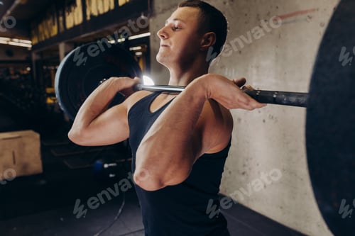 Preview: strong bodybuilder holding barbell at gym