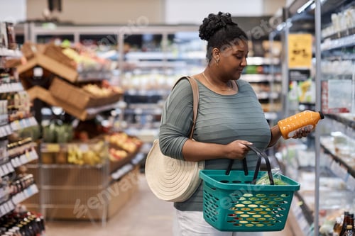 Preview: Real black woman shopping for groceries in supermarket and buying dairy products
