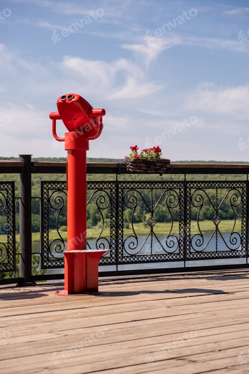 Preview: Public stationary binoculars on the banks of the river in summer