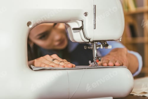 Preview: seamstress sewing cloth with sewing machine on foreground